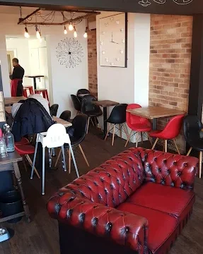 Inviting coffee shop interior with comfortable seating, exposed brick walls, and warm lighting, perfect for relaxing with a hot drink.
