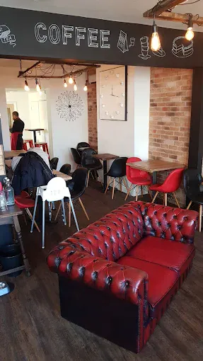 Inviting coffee shop interior with comfortable seating, exposed brick walls, and warm lighting, perfect for relaxing with a hot drink.