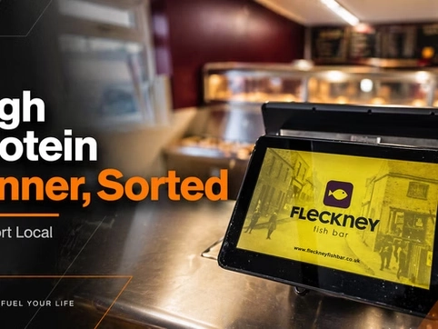Digital menu screen at Fleckney bar displaying food options in a modern setting.