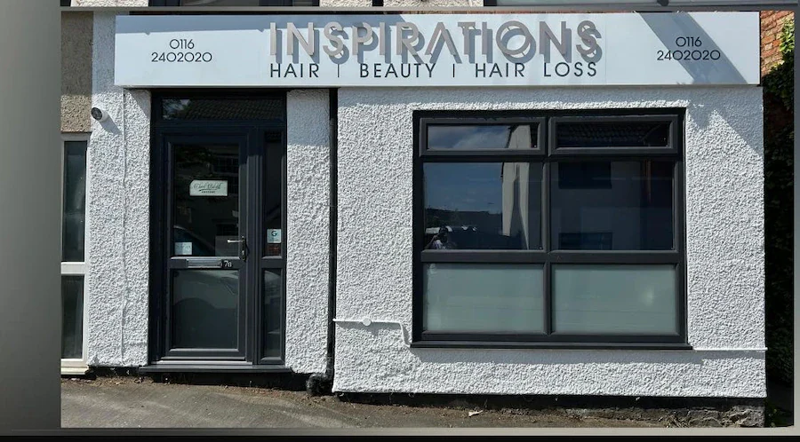 Modern exterior of Inspirations Hair, Beauty & Hair Loss salon in Fleckney, featuring a grey textured facade, black window frames, and a glass door.