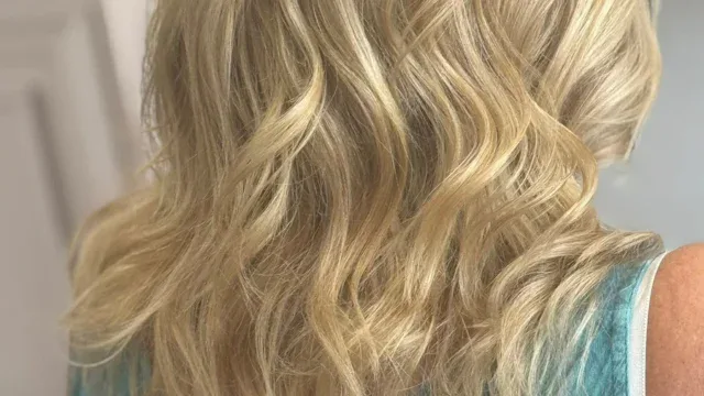 Close-up of a woman with shoulder-length, soft blonde wavy hair, showcasing healthy, shiny locks perfect for a casual or professional look.