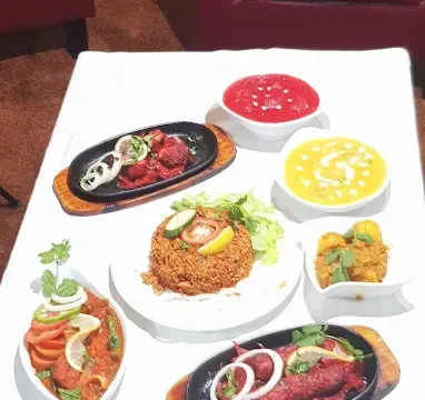 Assorted Indian dishes including curries, rice, and sauces served on a table at Fleckney Indian Cuisine.