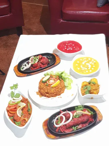Assorted Indian dishes including curries, rice, and sauces served on a table at Fleckney Indian Cuisine.