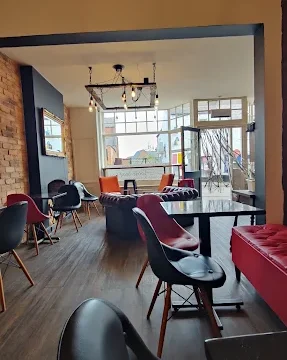 Stylish café interior featuring contemporary furniture, large windows, and warm lighting creating a welcoming atmosphere for visitors.