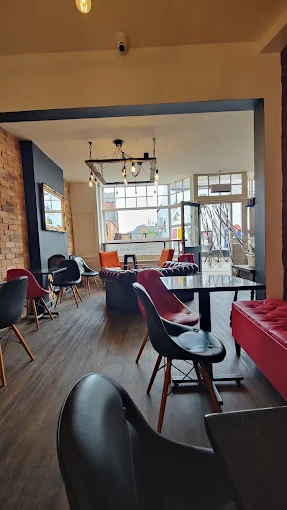 Stylish café interior featuring contemporary furniture, large windows, and warm lighting creating a welcoming atmosphere for visitors.